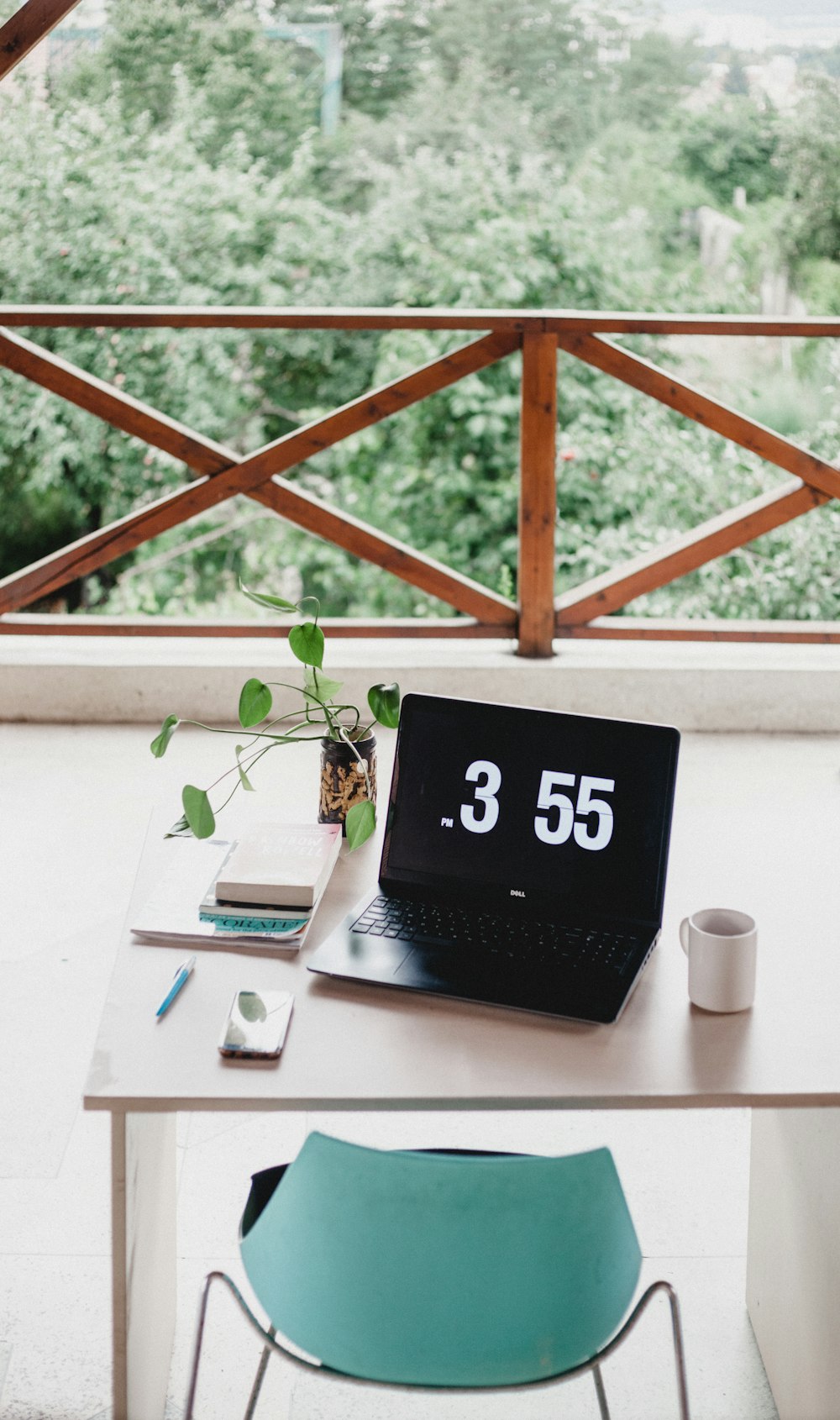 allumé ordinateur portable sur la table à côté de la tasse avec la chaise