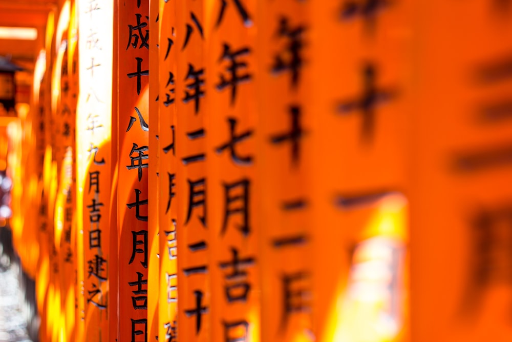 eine Reihe orangefarbener Schilder mit asiatischer Aufschrift