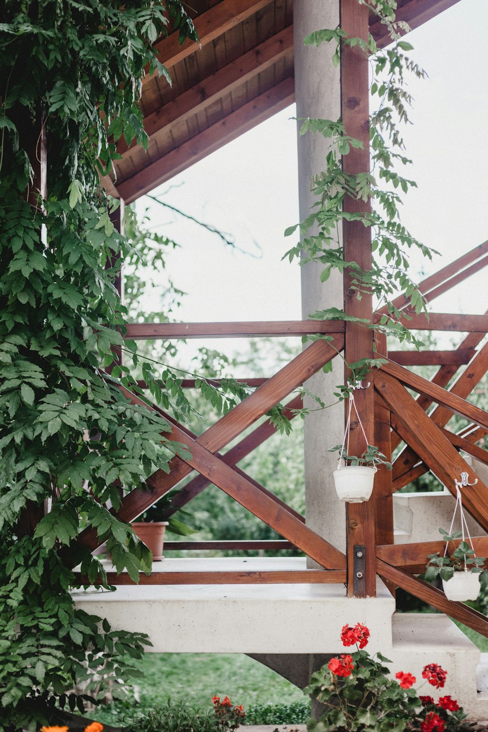 red flowers beside porch with stairs and railing