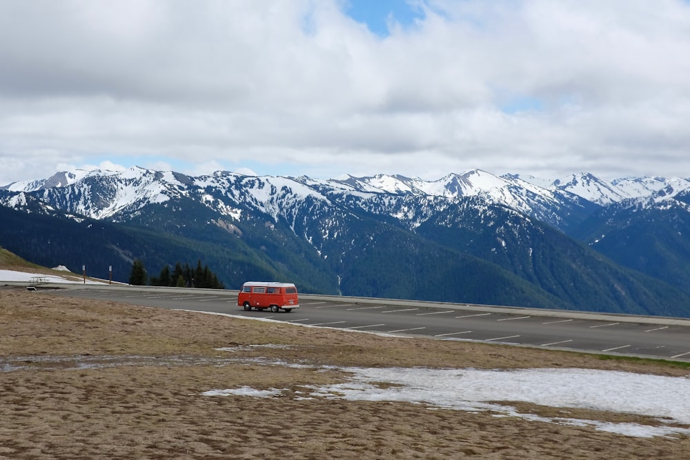 yellow Type B motorhome on road near mountain under cumulus