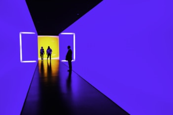 three person standing near wall inside building