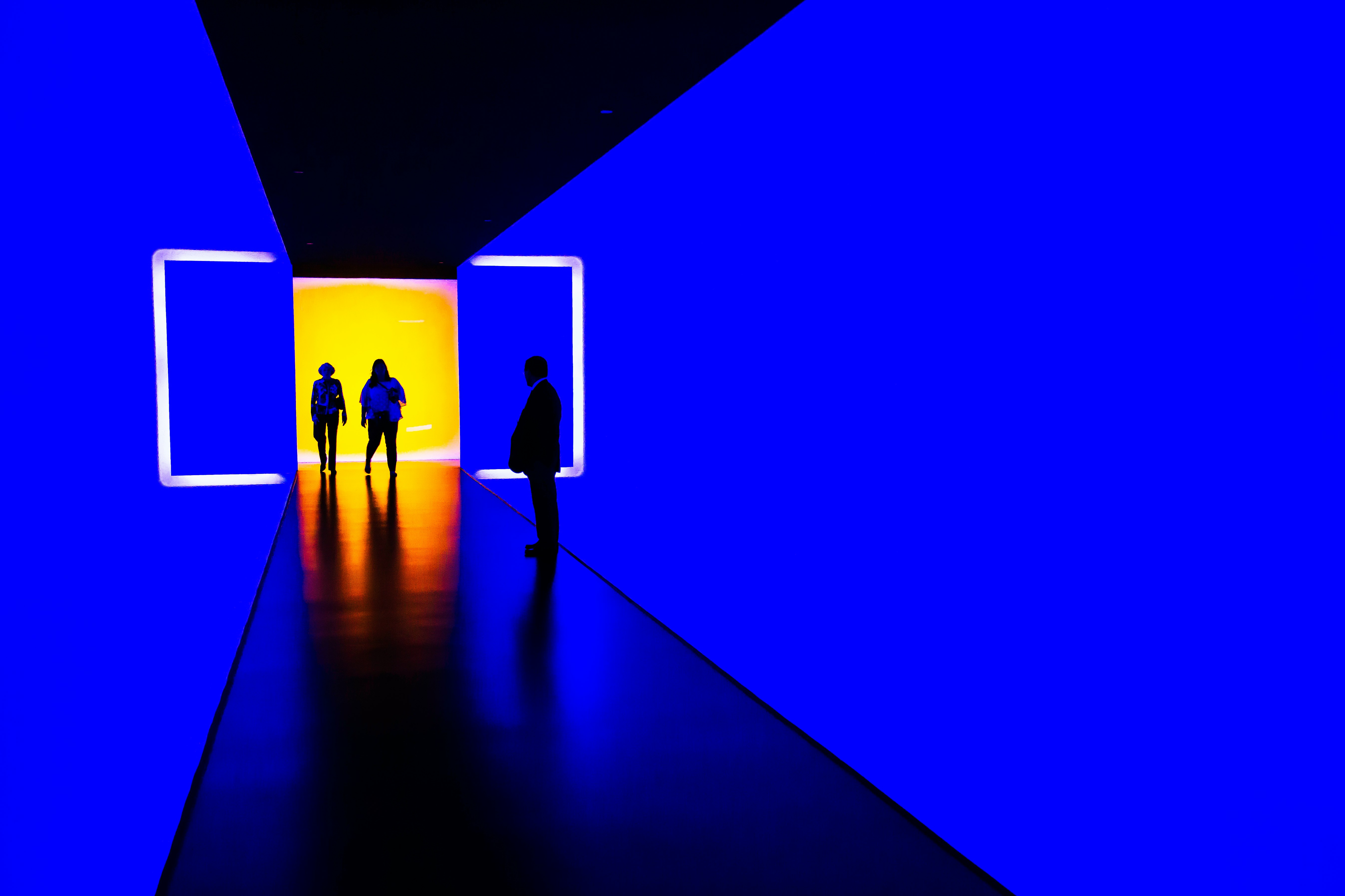 three person standing near wall inside building