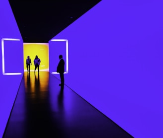 three person standing near wall inside building