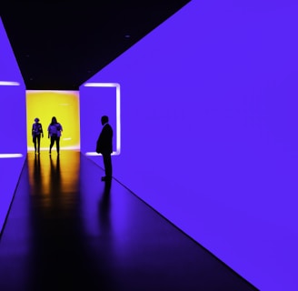 three person standing near wall inside building