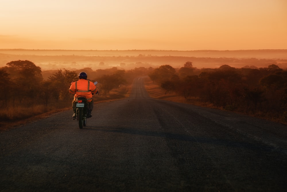 man riding on motorcycle between trees