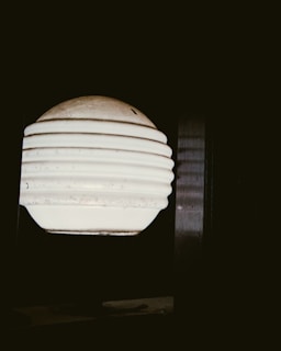 Soft white light from a contemporary lamp highlighting the texture of a smooth gray surface