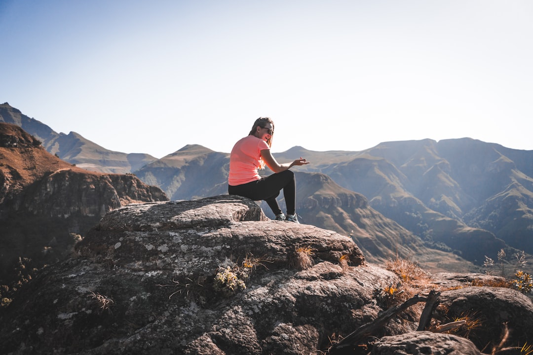 woman sitting on mountain peak