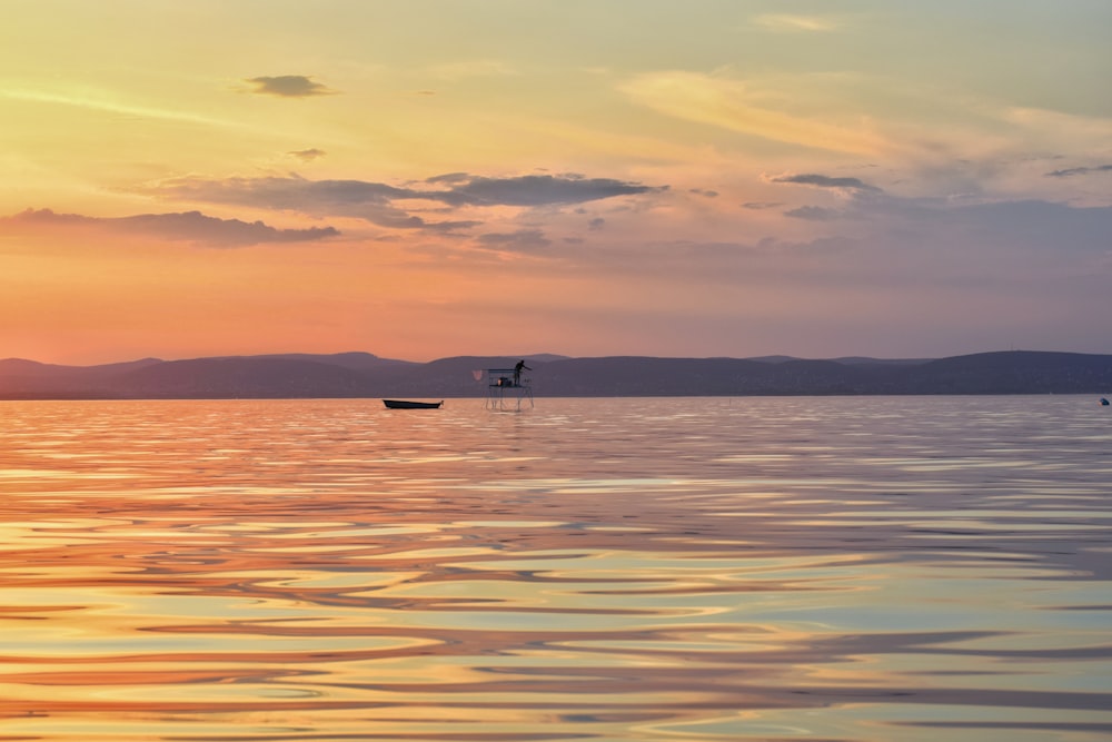 photography of black boat on body of water