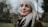 white haired woman standing near trees