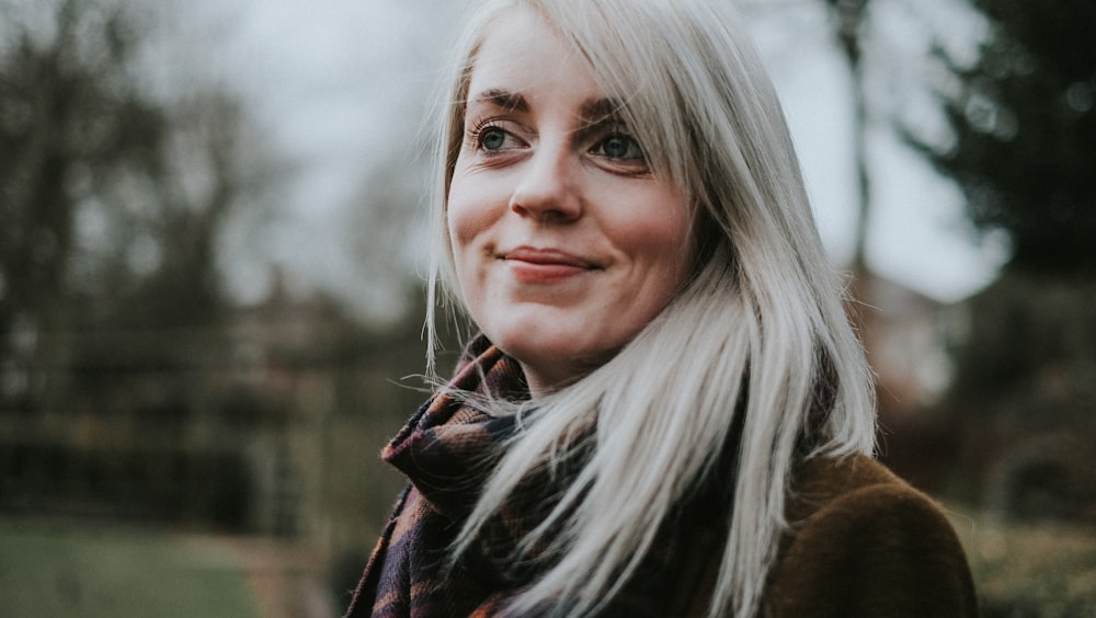 white haired woman standing near trees