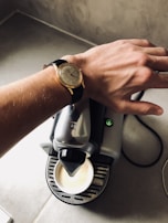 A person wearing a modern watch while enjoying a coffee.