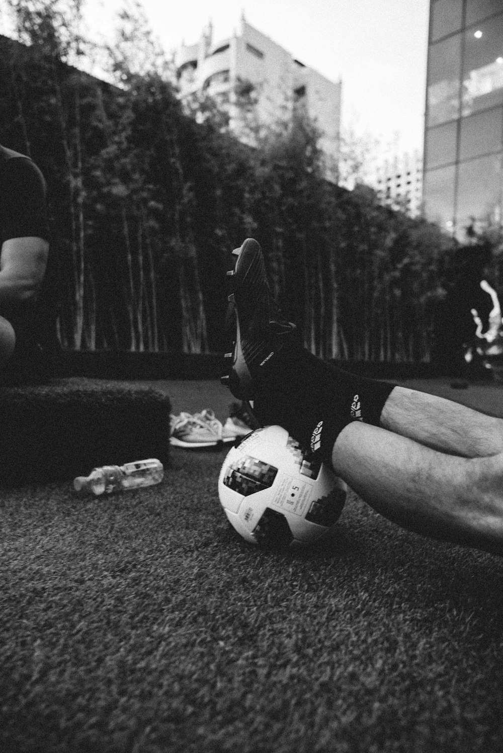 축구공에 사람의 발을 찍은 회색조 사진