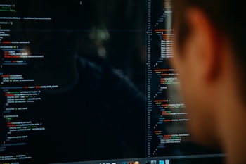 Back of man's head in front of code on screen
