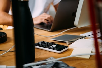 Person working at a desk with financial documents and laptop