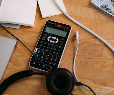 black scientific calculator beside black headphones