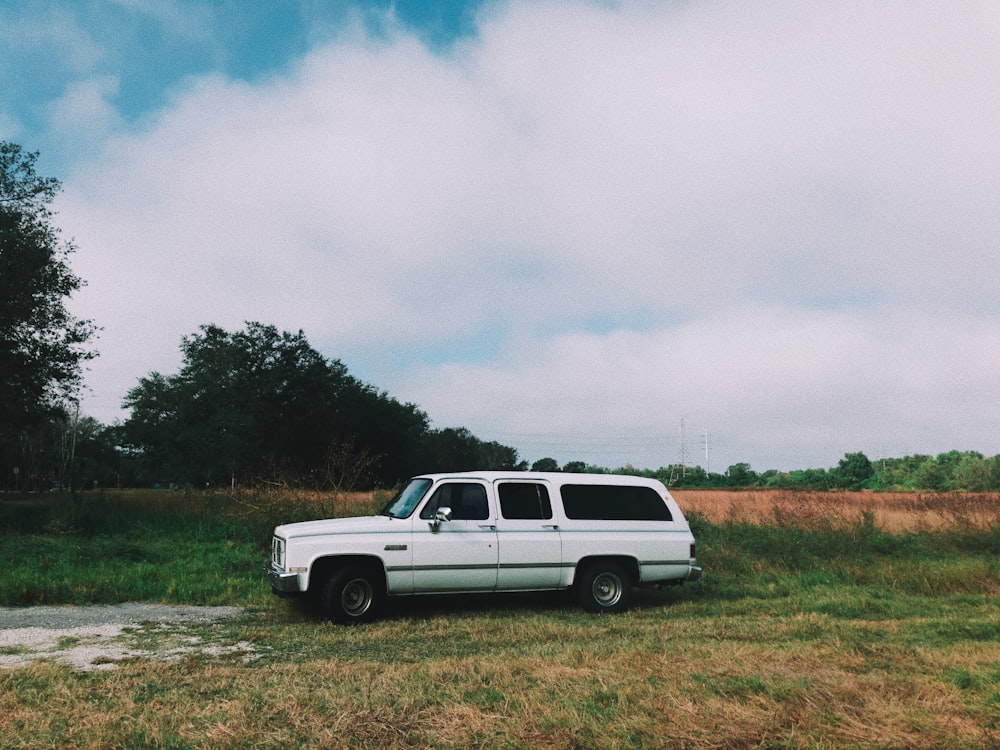 white station wagon on grass field