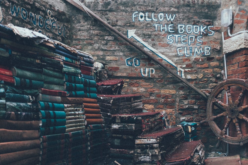 pile of books beside ship's wheel