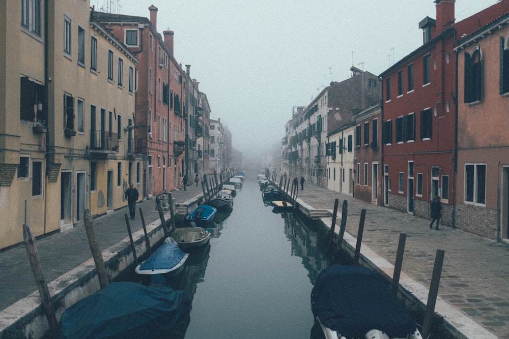 Persona in piedi accanto all'acqua tra le case