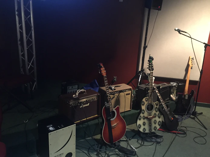 A cozy music studio with bass guitars and amplifiers neatly arranged.