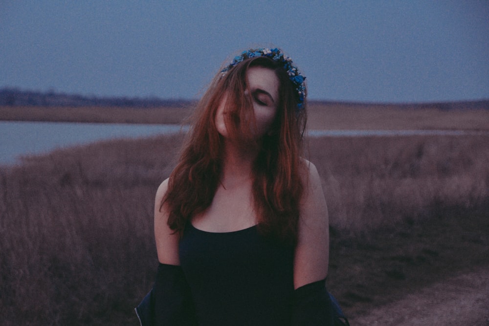 selective focus photography of woman standing near lake