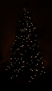 LED acrylic lamp shaped like a Christmas tree glowing softly in a cozy room setting.