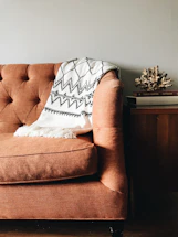 white and black textile on brown couch