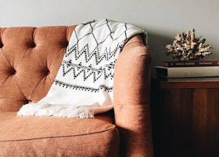 white and black textile on brown couch