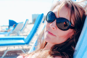 Woman relaxing on a beach chair wearing a chic oversized shirt and matching pareô