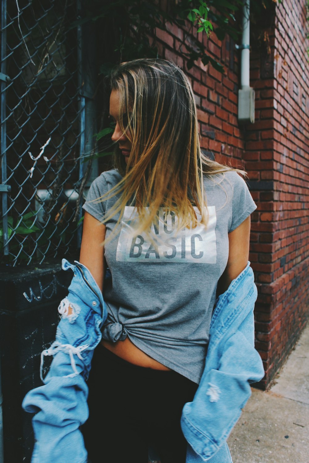 woman wearing gray and white crew-neck shirt facing sideways at daytime