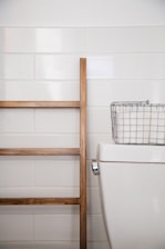 stainless steel basket on top white ceramic toilet bowl