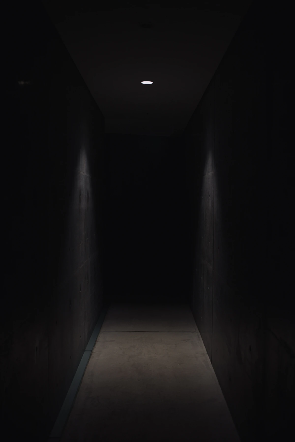 Lorong gelap yang diterangi satu lampu kecil.