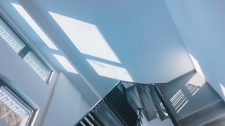Close-up of a minimalist staircase with sharp angles and natural light casting shadows.