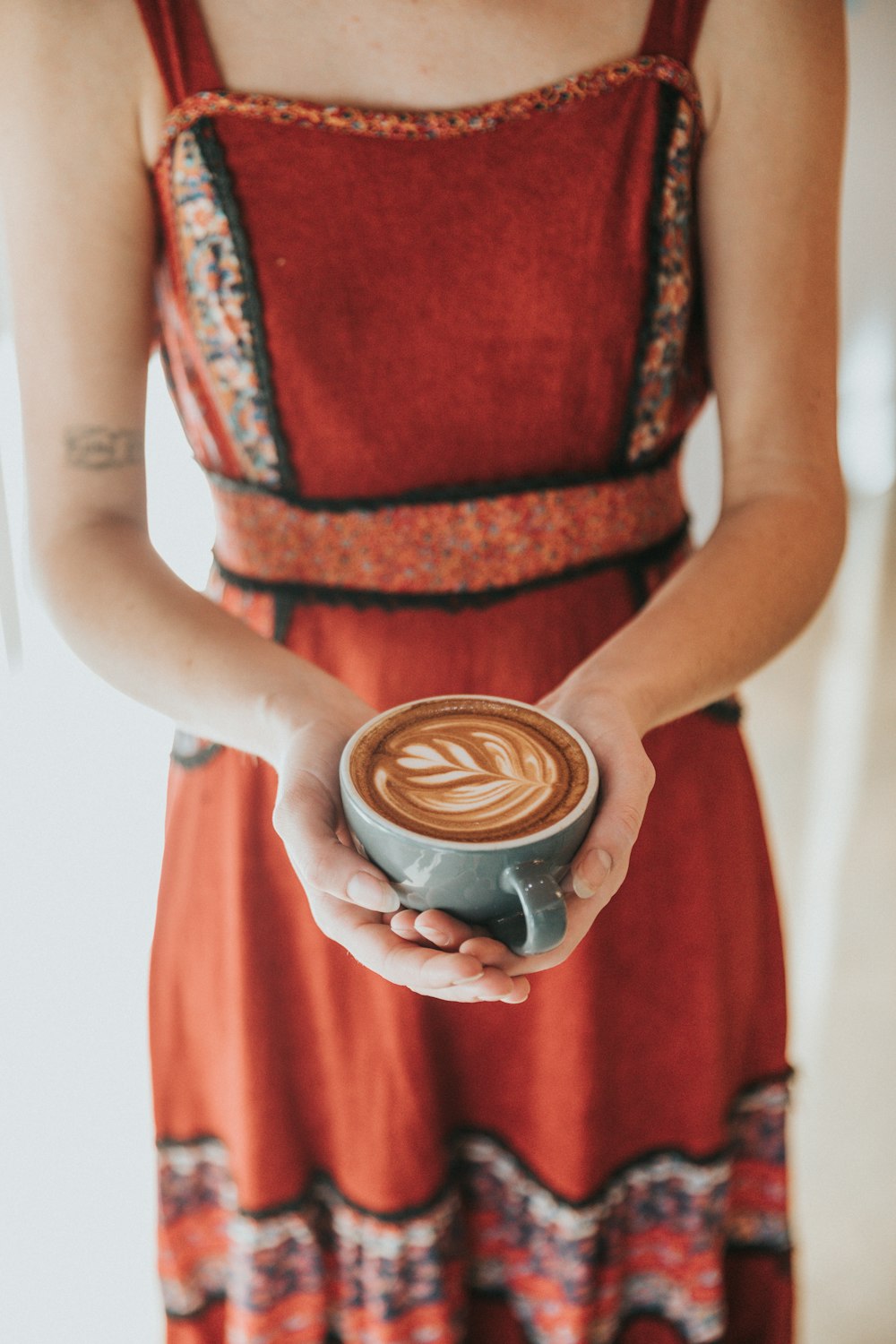 Frau trägt Kaffee-Latte mit Kunst