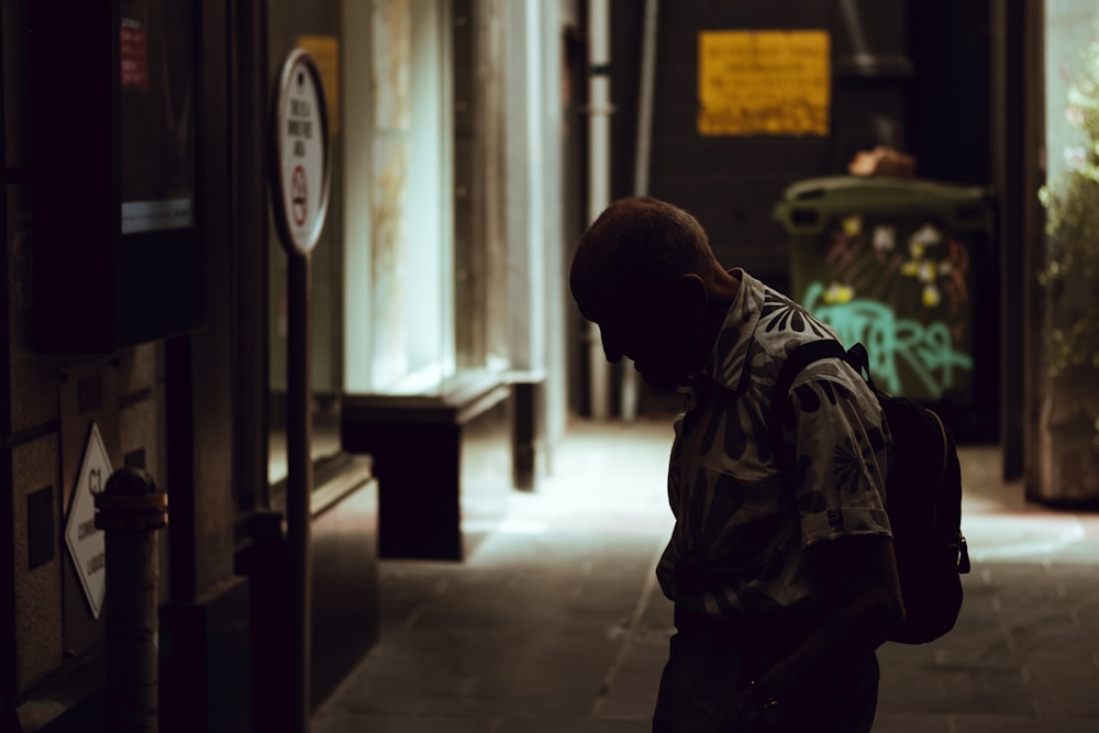 a man with a backpack walking down a hallway