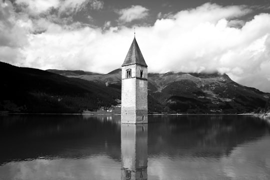 concrete building in grayscale photography in Kirchturm von Altgraun Italy