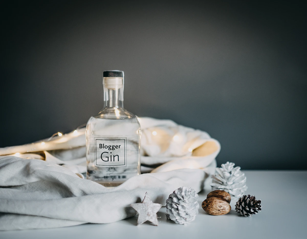 Garrafa de gin ao lado de um copo em uma mesa de madeira