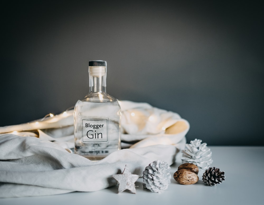 Blogger Gin glass bottle on white wooden table