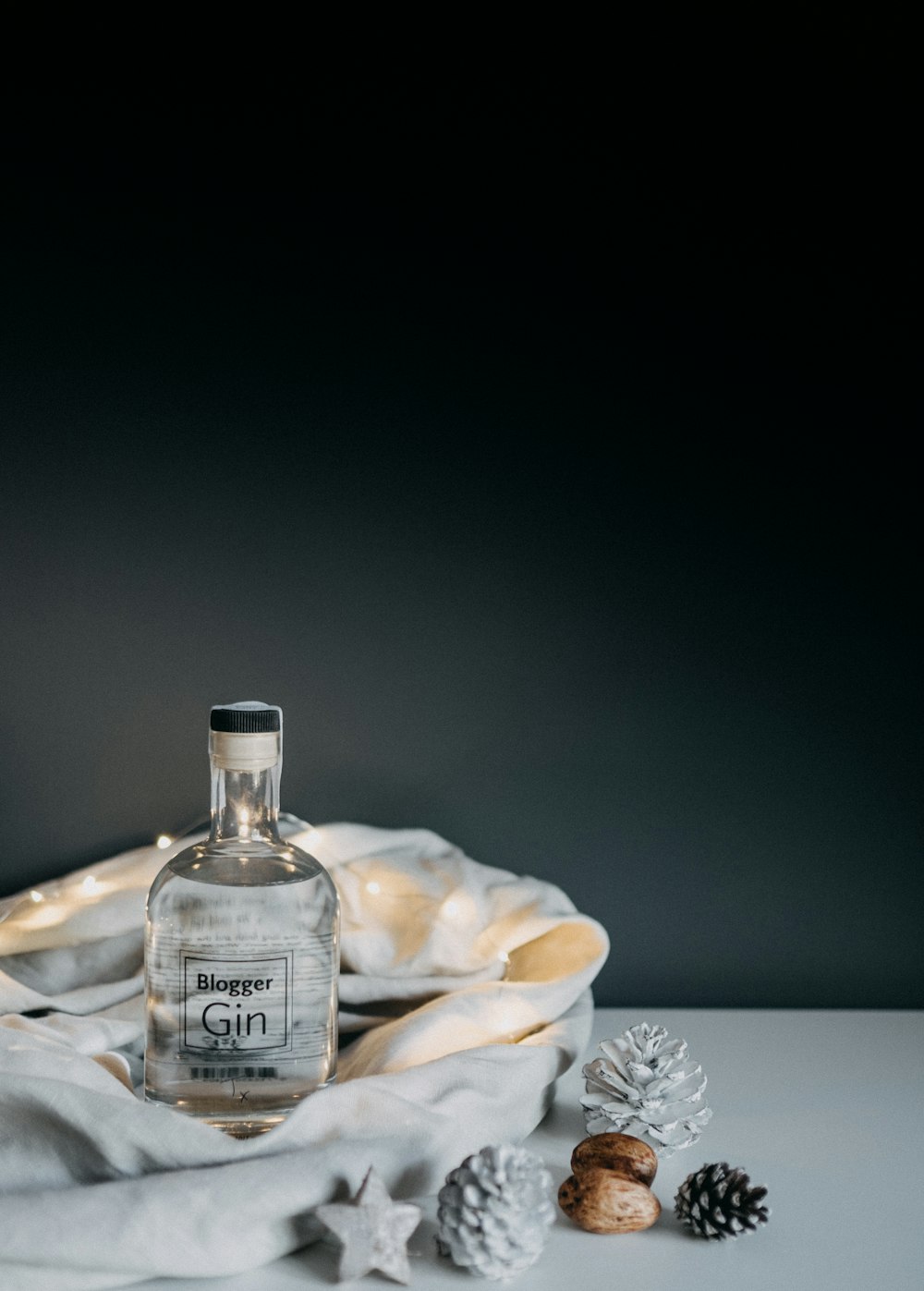Botella de vidrio Blogger Gin sobre superficie de madera blanca