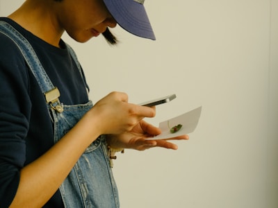 User taking a photo of a plant leaf with a smartphone outdoors