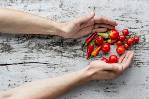 person hand's about to get cherry tomatoes and bell peppers