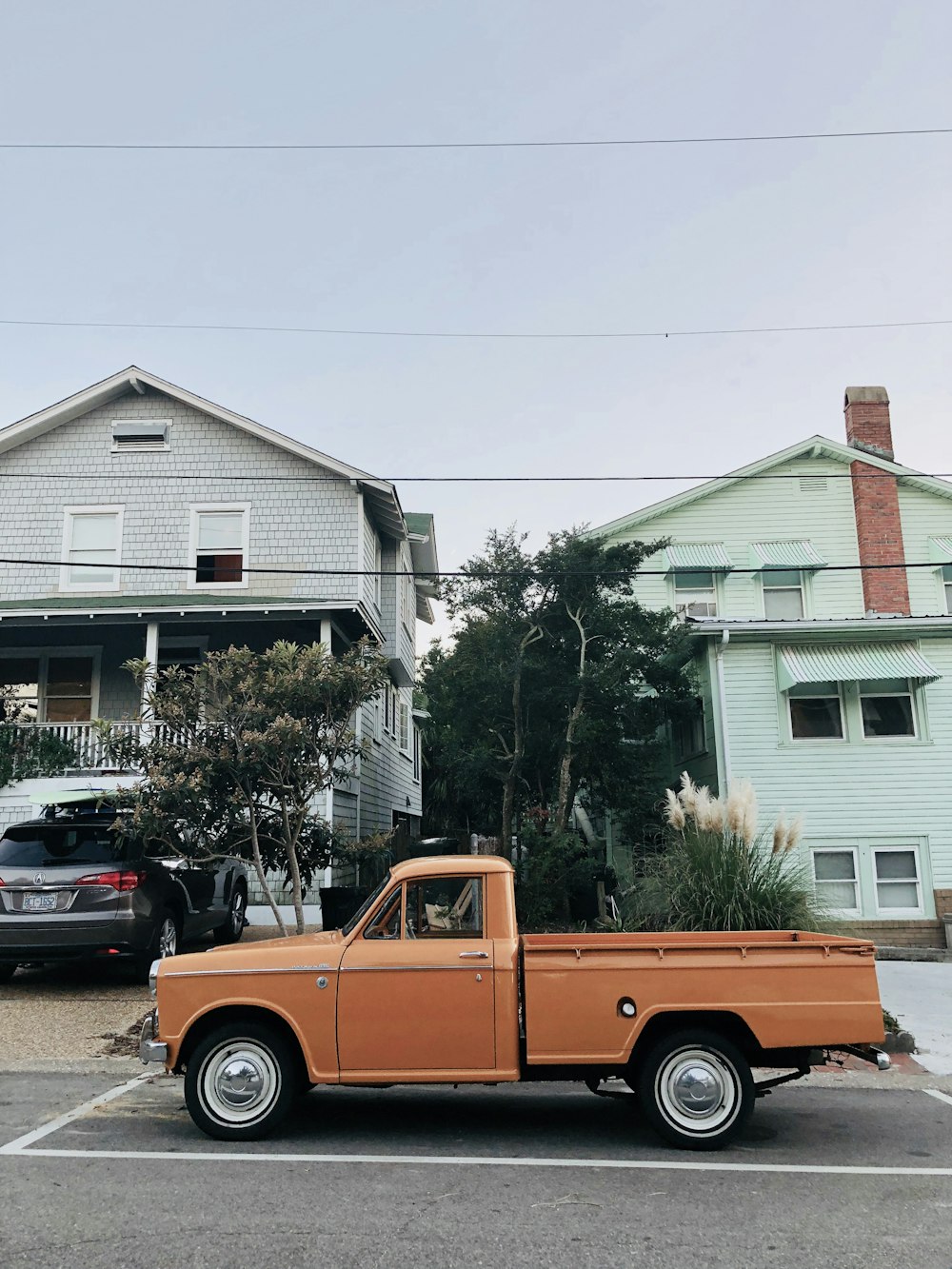 an orange pickup truck parked in a parking lot