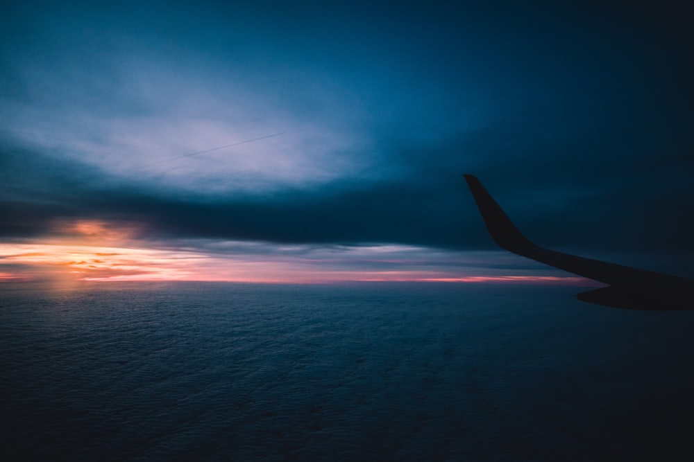 silhouette of airplane flying through sky