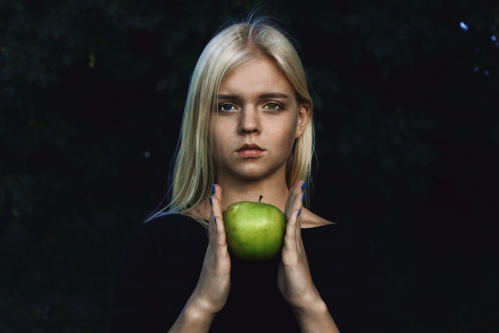 mulher segurando maçã verde