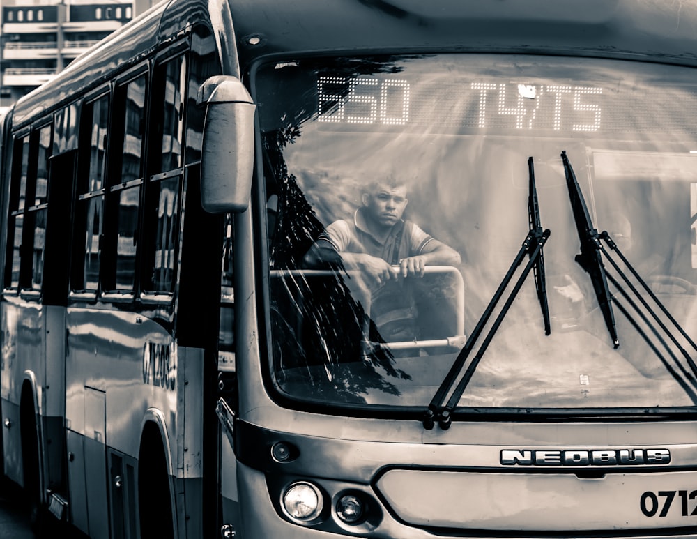 grayscale photo of man inside bus