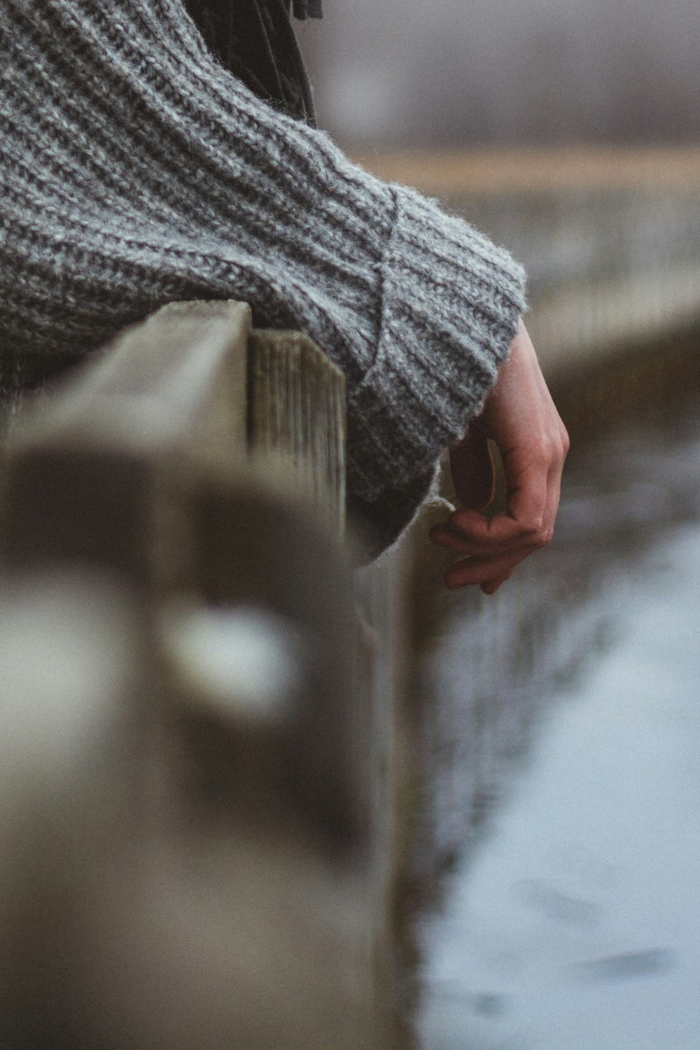 person leaning on brown wooden fence during daytime