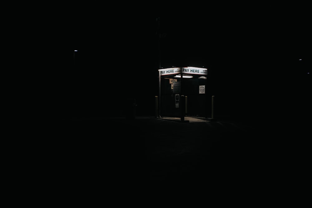 a phone booth in the dark with a sign on it