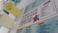 A menu with a distinctive quote and colorful cartoon graphic is prominently featured. Two glasses filled with a light yellow beverage are placed next to the menu. The layout includes sections with lists of food and drinks, indicating a restaurant or cafe setting.