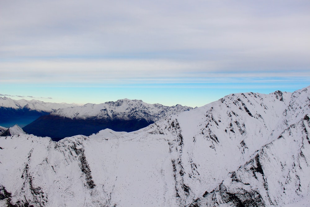 snow covered mountain under white clouds