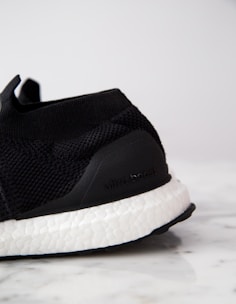 Close-up of Adidas Ultraboost sneakers with a street-style backdrop.