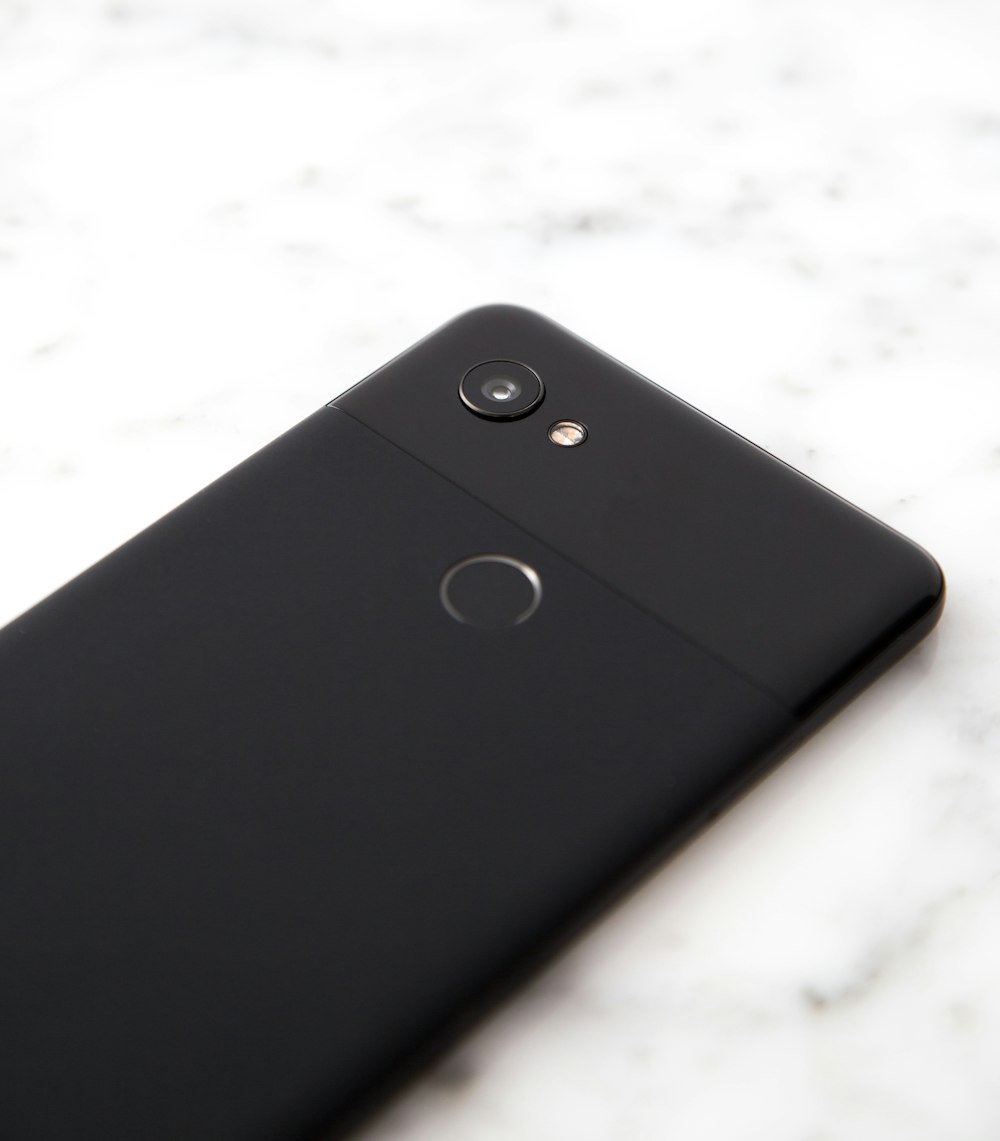 schwarzes Android-Smartphone auf grauer Oberfläche